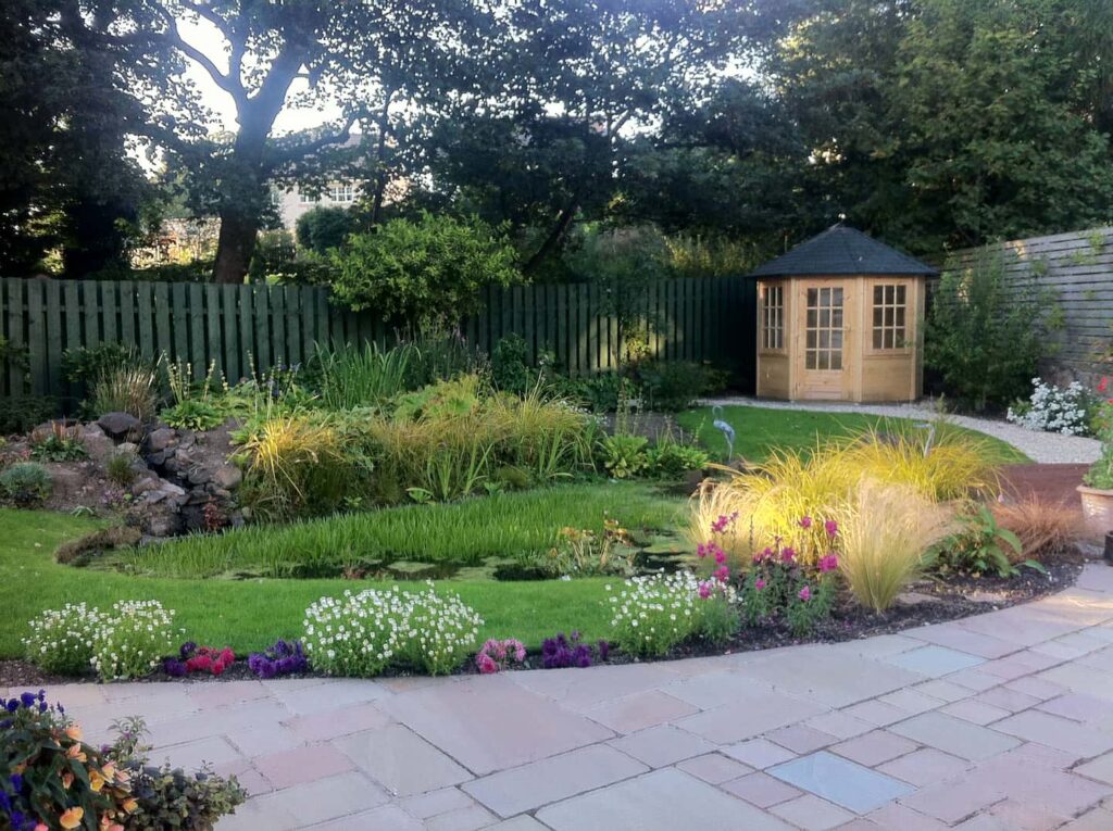 wonderfully landscaped garden featuring a pond and summer house